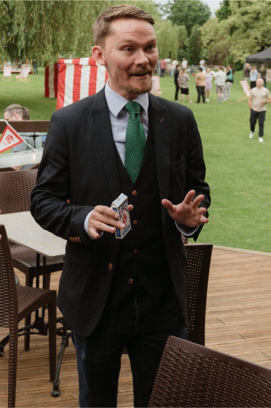 Ryan Beck performing magic at a table